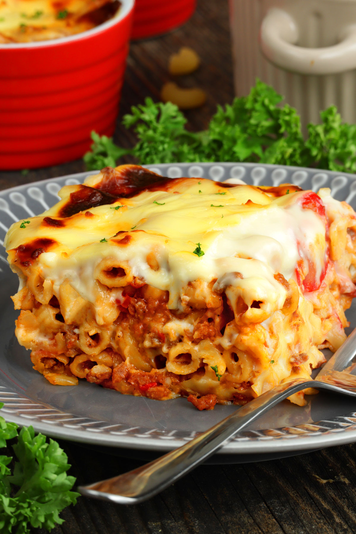 A square serving of cheesy baked macaroni on a plate. 