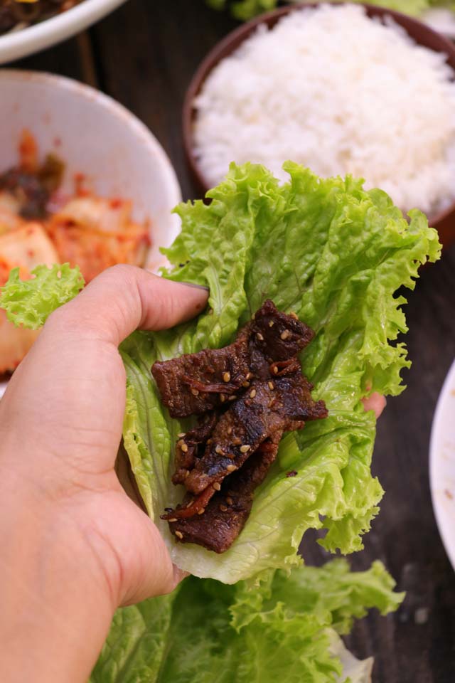 Bulgogi wrap in lettuce leaf with kimchi and rice