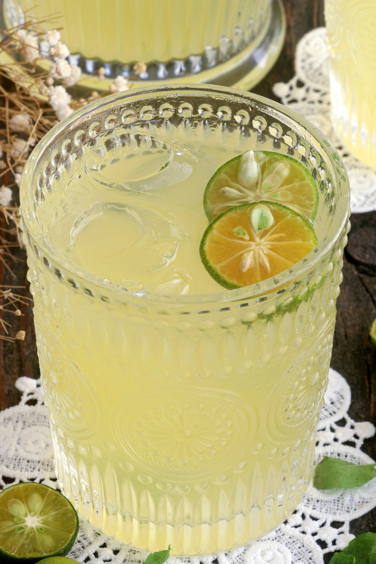 Calamansi juice in a glass served over ice with calamansi slices.