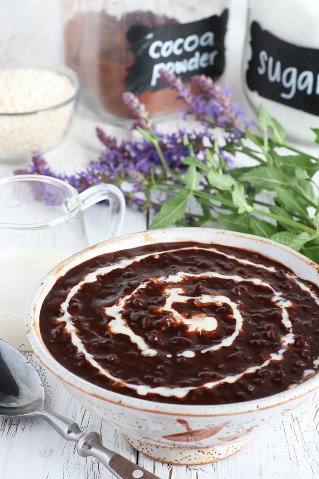 Chocolate rice pudding with evaporated milk on top served in a bowl.