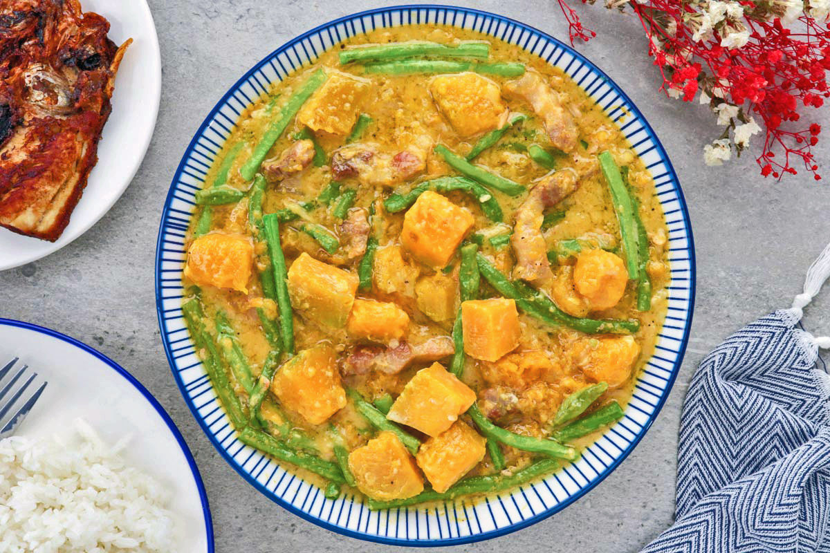 Ginataang Kalabasa at Sitaw in a serving bowl served with rice and fried fish.