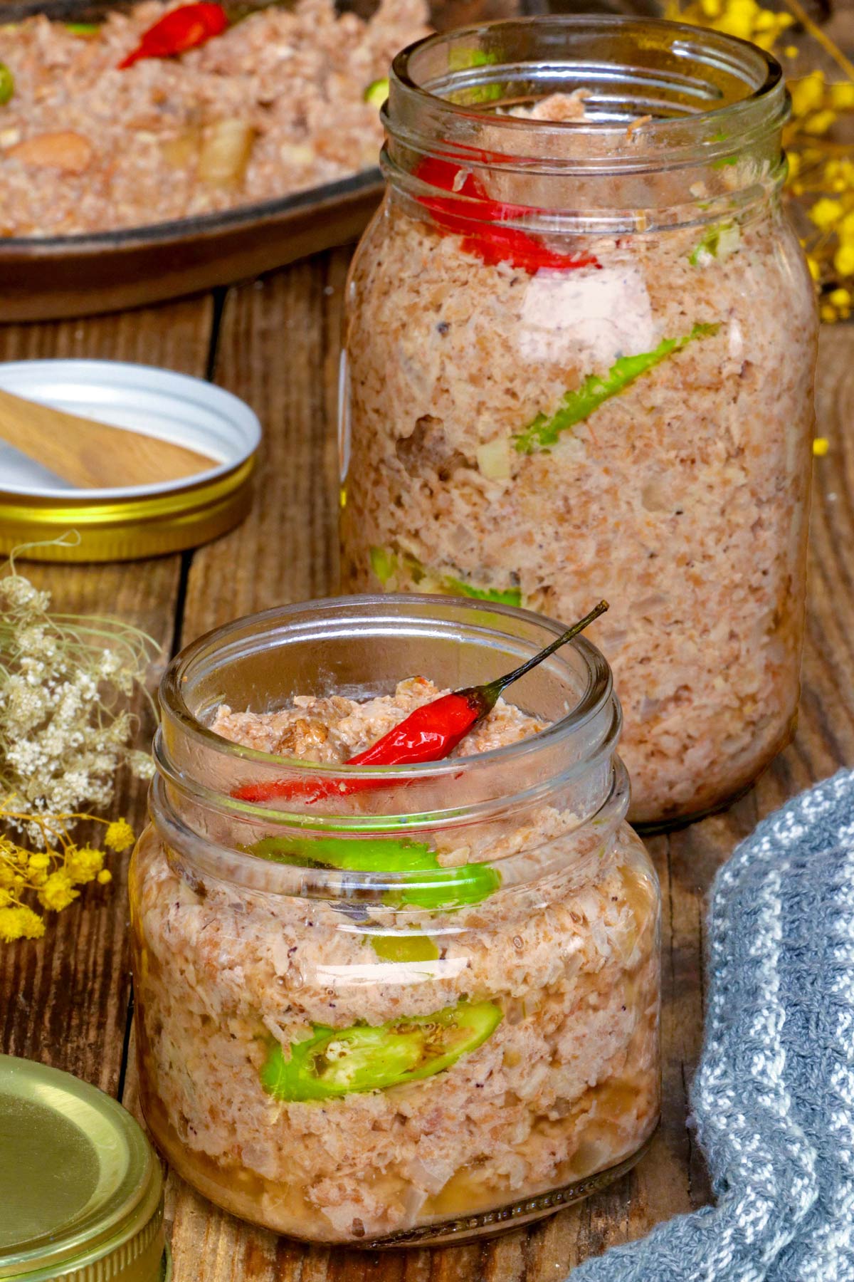 Sinantolan placed in jars with red and green chilis as garnish.