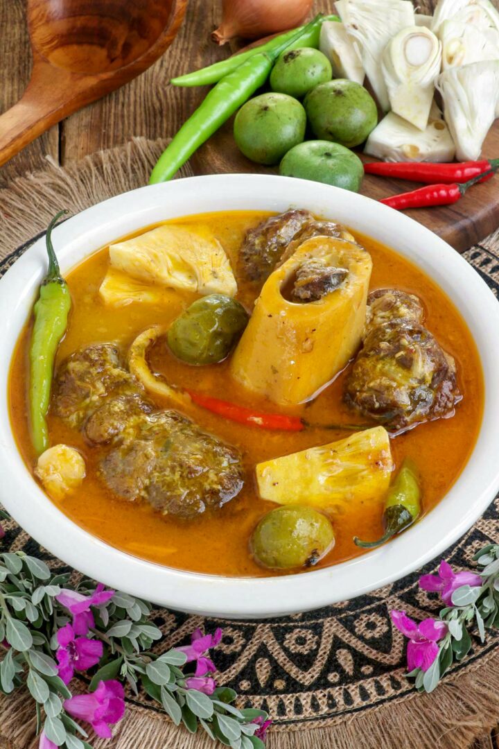 Kansi in a serving bowl made with beef shanks, green jackfruit, batwan, and chilis.