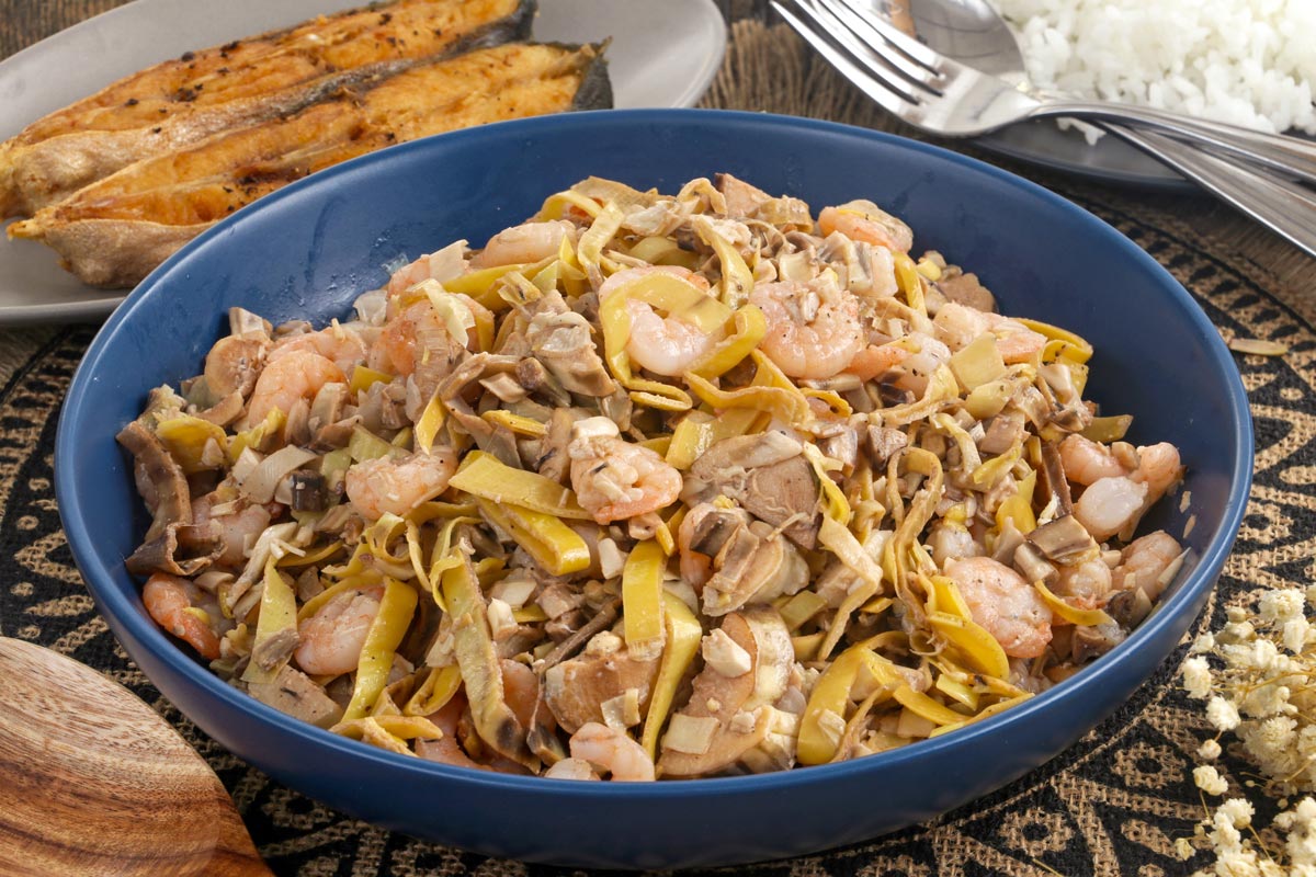 Kilawing puso ng saging in a serving bowl with fried fish and steamed rice.