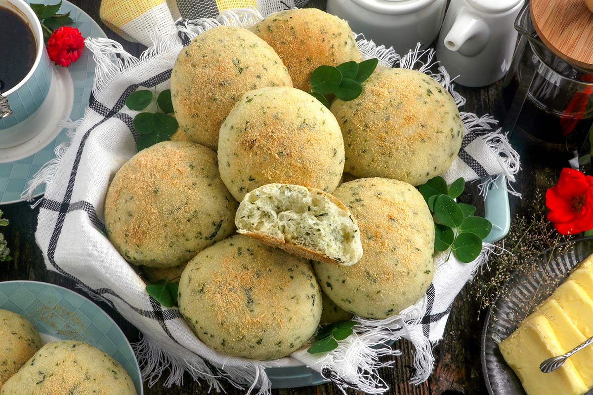 Malunggay Pandesal on a serving basket served with coffee and butter.