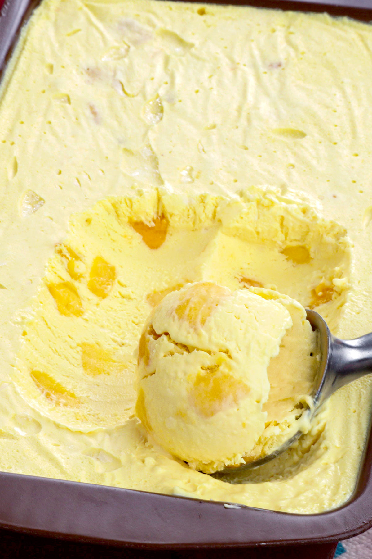 A scoop of mango ice cream on a container.