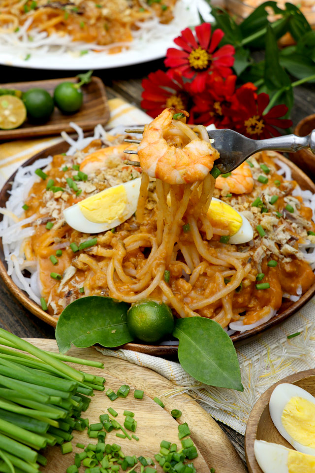 Pancit Luglug with hard-boiled eggs, shrimp, pork rind, and shredded smoked fish