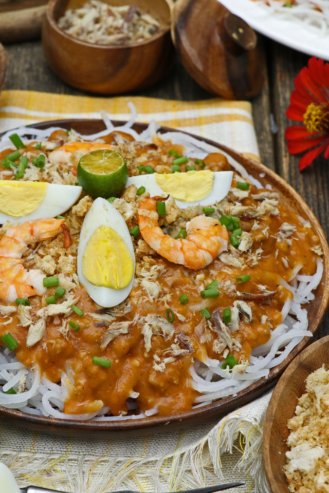 Pancit Luglug using thick cornstarch noodles with orange savory sauce and toppings 