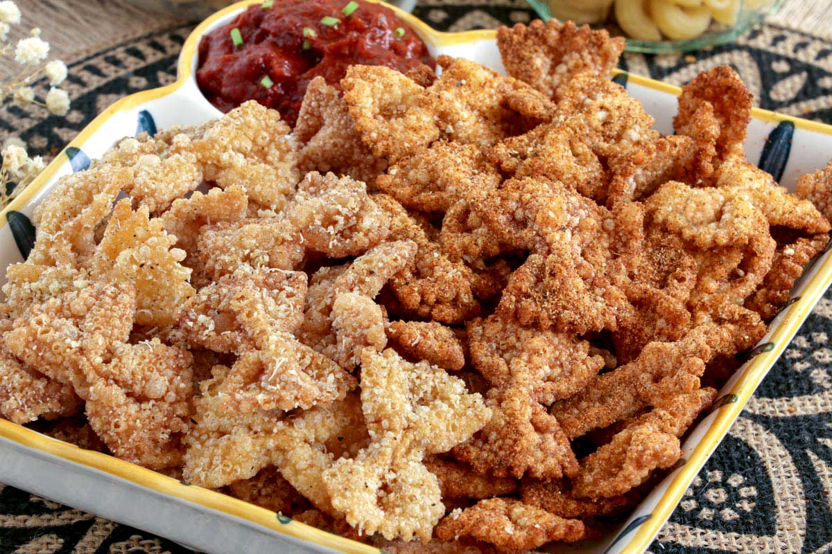 Fried pasta chips in a serving bowl with marinara sauce.