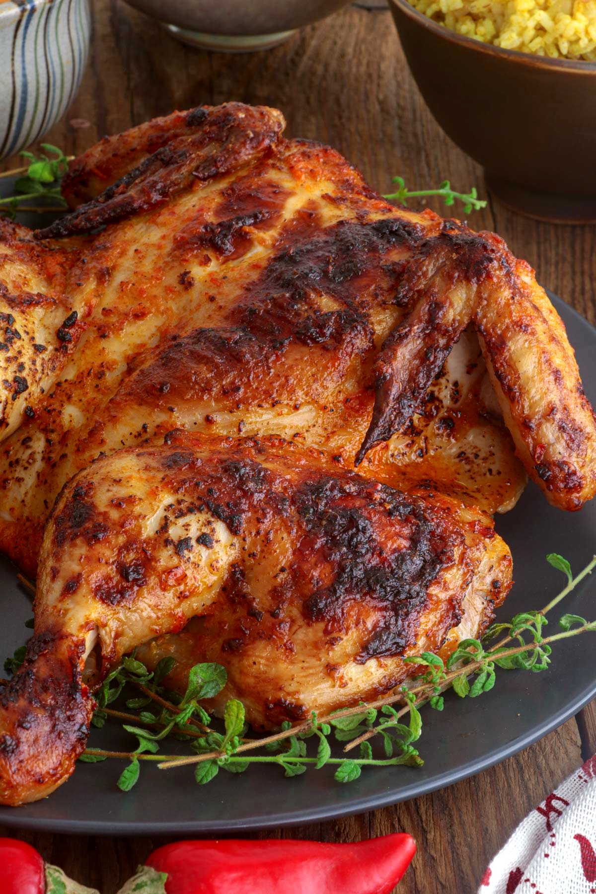 Chicken Peri peri on a serving plate with lemon wedges.