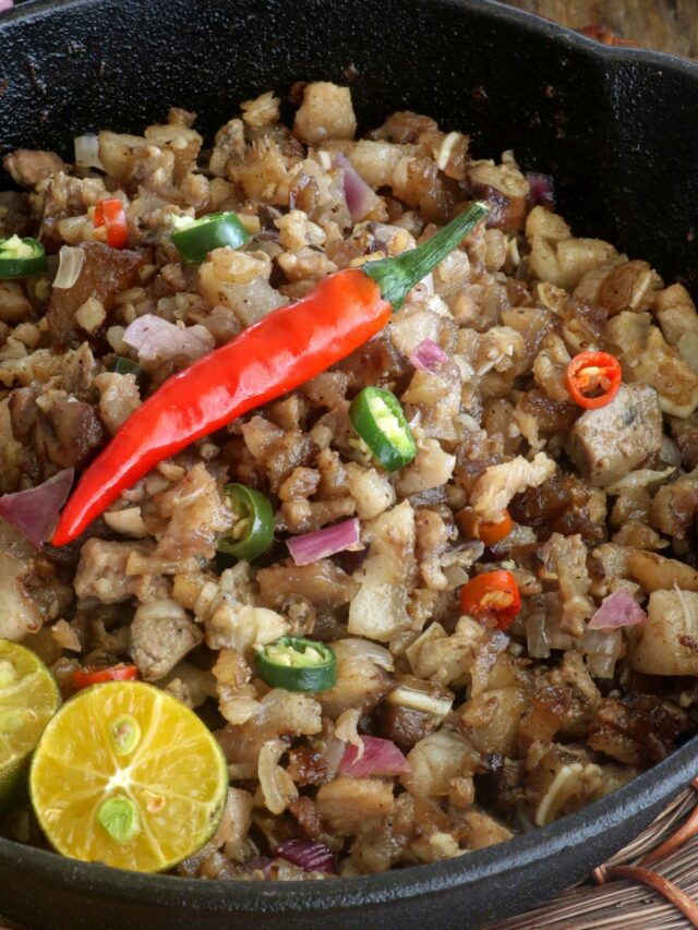 Sizzling sisig in a cast iron pan.