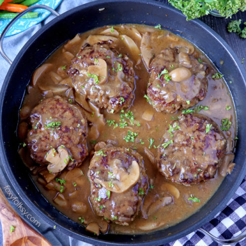 Try this simple Salisbury Steak recipe complete with Mushroom Gravy! So tender and juicy Steak patties swimming in thick tasty gravy! | www.foxyfolksy.com