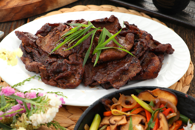 Cooked thin cuts of beef sirloin with rice on a plate.